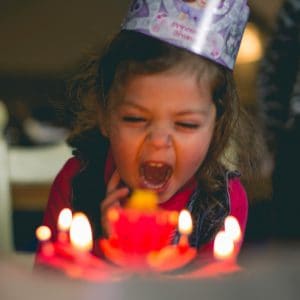Ein Kind vor einem Geburtstagskuchen