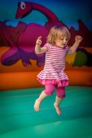 Cute little girl jumping inside the inflatable bouncy castle